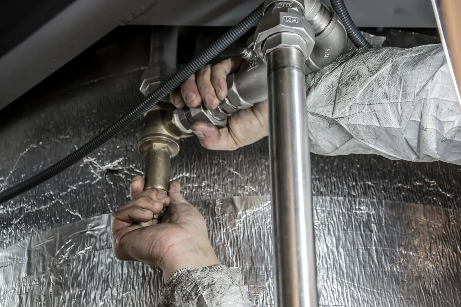Plumber tightening a fitting on a water line