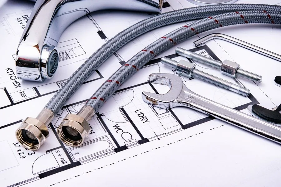 Plumbing tools and hoses laid out on a floor plan